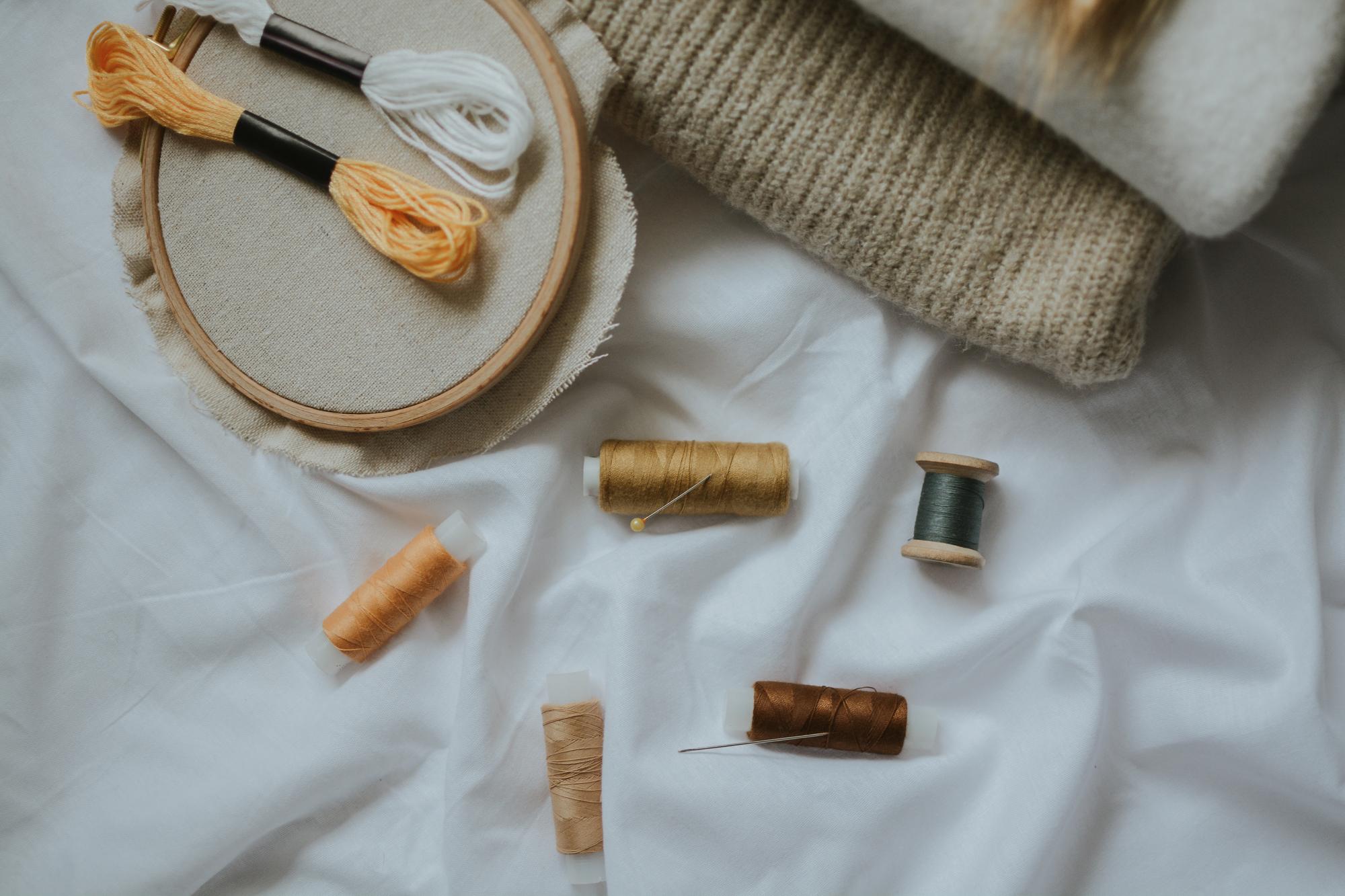 Workshop table with threads and a stitched sample
